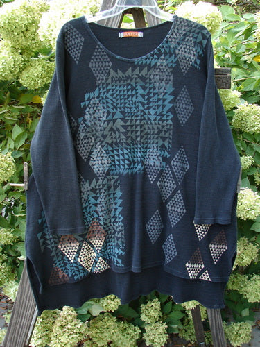Barclay Thermal Shirttail Top with mosaic design on a clothes rack, featuring a shirttail hemline, shaped neckline, and longer sleeves, from Bluefishfinder.com.