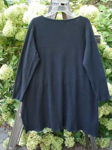 Barclay Thermal Shirttail Top Continuous Mosaic Black Size 1 displayed on a clothes rack, showcasing its long sleeves, A-line shape, and vented sides.