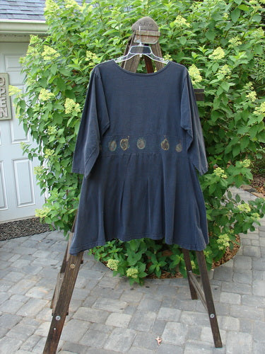A 1993 Sage Dress Bountiful Black Size 1, featuring a blue shirt on a swinger, a close-up of a plant, and a pair of glasses on a wooden stand.