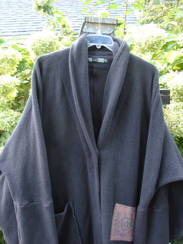 Barclay Patched Celtic Moss Deco Coat Farmhouse Brum OSFA displayed on a model, featuring a dense cotton fleece, oversized vintage button, deep arms, and a lower pocket in an outdoor setting.