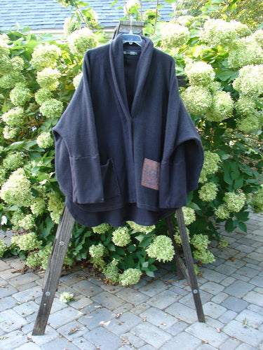 Barclay Patched Celtic Moss Deco Coat Farmhouse Brum OSFA displayed on a wooden stand, showcasing its thick cotton fleece, oversized button, deep V neckline with stand-up collar, and large lower pocket.