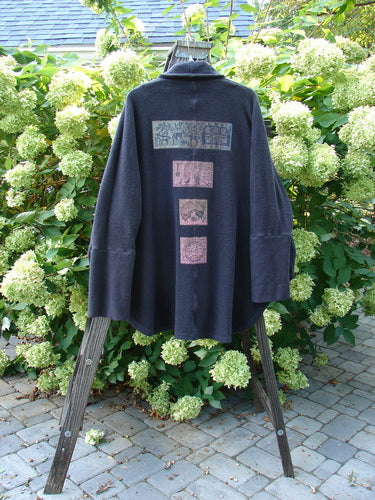 Barclay Patched Celtic Moss Deco Coat Farmhouse Brum OSFA displayed on a stand, showcasing its dense cotton fleece, double-button hold, deep V neckline, oversized pocket, and unique farmhouse patches.