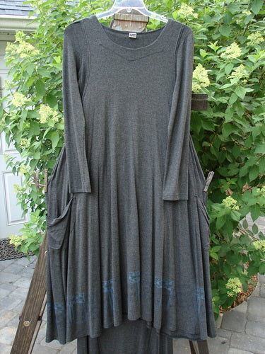 2000 Rayon Lycra Midi Bubble Trio Sparkle Border Charcoal Size 1 2 displayed on a rack, featuring a long grey dress with unique fall, dippy pockets, and a gentle scooped neckline.