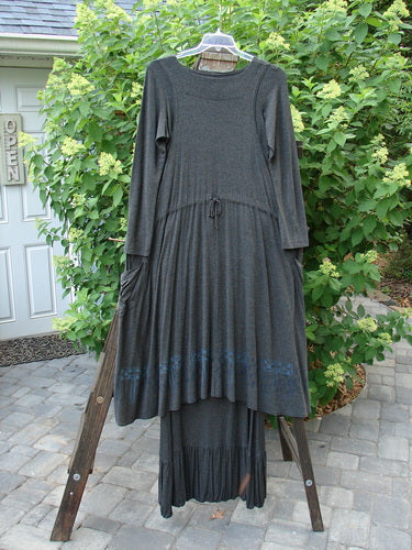2000 Rayon Lycra Midi Bubble Trio Sparkle Border Charcoal Size 1 2: A dress on a clothes rack, long grey dress on a tree, and black dress on a wooden ladder.