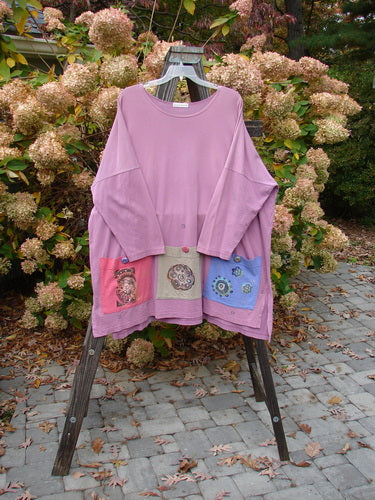 Image alt text: "1997 Collage Top Petal Power Crocus OSFA: A pink shirt with different designs on it, featuring an A-lined shape, drop shoulders, vented sides, and oversized front pockets with vintage knot buttons. Made from mid-weight organic cotton. Perfect condition."