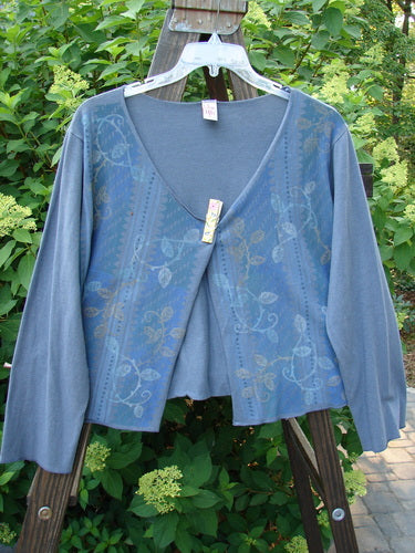 Barclay Cotton Lycra Long Sleeved Shrug Trail Vine Stormy Size 1 displayed on a hanger, showcasing its open front, long sleeves, and painted trailing garden vine design.