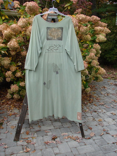 1995 Farmer Jen Dress Fall Leaves Dinette Green Size 2, featuring a wider neckline, long sleeves, multiple pockets, and center lower pleats, displayed on a rack.