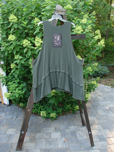Barclay Thermal Patched Susset Vest on a wooden rack, featuring rolled top front pockets, detachable bottom flounce, deep arm openings, wooden front buttons, and painted patches.