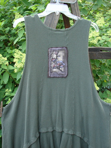 Barclay Thermal Patched Susset Vest with detachable bottom flounce, deep arm openings, wooden buttons, and painted patches. Features rolled top front pockets and vertical exterior rear seams.