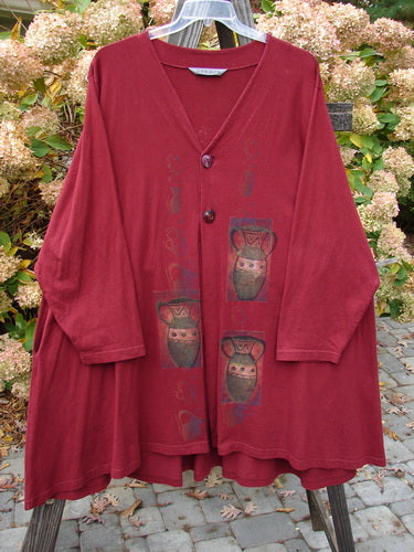 1997 Mask Jacket Primitive Vase Regalia Size 2: A red long sleeved shirt with a bell shape and two special button closure. Features deep side pockets and a rounded swing hemline.