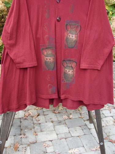 1997 Mask Jacket with Primitive Vase design in Regalia. Red jacket with a bell shape and two special button closure. Features deep side pockets and a varying swing hemline. Made from mid-weight cotton. Perfect condition. Size 2.