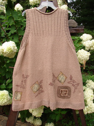 Image: A brown knitted dress on a tree. Product: 1998 Teton Sweater Vest Tiny Twig Aspen OSFA. Description: A vintage sweater vest from the Holiday Winter Collection of 1998. Features include an A-line shape, alternative stitching, colorful ceramic buttons, a deeper V neckline, and a ribbed hemline. The vest is adorned with a tiny twig theme paint and a fully knitted Blue Fish patch. Bust: 48, Waist: 50, Hips: 58, Hem Circumference: 68, Length: 35 inches.