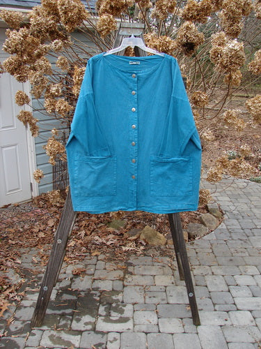Barclay Cotton Sleeve Hemp Jacket Unpainted Aqua Size 2 displayed on a swinger, featuring a full metal button front, rounded boatneck, two oversized pockets, and slimmer sleeves with sectional vertical panels.