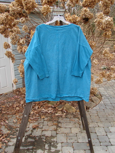 Barclay Cotton Sleeve Hemp Jacket in Aqua Size 2, displayed on an outdoor clothesline. Features full metal button front, rounded boatneck, and two oversized pockets.