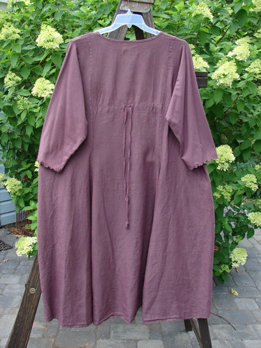 Barclay Linen Cotton Sleeve Upper Pocket Dress Unpainted Red Plum Size 2 displayed on a swing, showcasing three-quarter sleeves, rounded neckline, and drawcord back with an A-line flair.