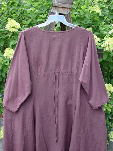Barclay Linen Cotton Sleeve Upper Pocket Dress Unpainted Red Plum Size 2 displayed on a swinger, featuring a rounded neckline, sectional panels, horizontal upper bodice pocket, drawcord back, and three-quarter length sleeves.