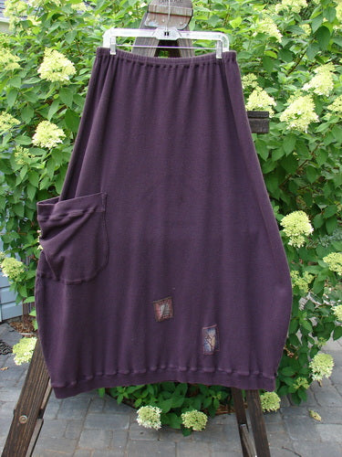 Barclay Patched Thermal Side Pocket Skirt Dream Red Plum Size 2, displayed on a clothesline, highlighting the ribbed hemline, vertical panels, oversized bottom side pocket, and full elastic waistline.