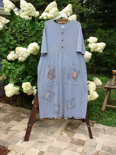 1999 Sukura Dress Asian Fan Bluestone Size 2 displayed on a hanger, showcasing a three-button front, optional accent belt, elongated front pockets, and a gathered rear skirt.
