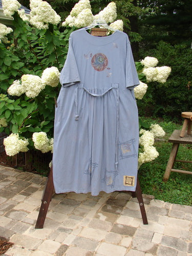 1999 Sukura Dress Asian Fan Bluestone Size 2 displayed on a clothesline, highlighting its three-button front, optional belt, large front pockets, and gathered rear skirt.