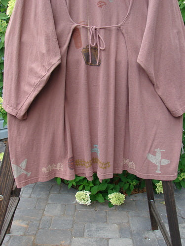 1993 Blueline Jacket in Dried Rose with antique aircraft design, displayed on a rack, showcasing its unique A-line shape, colorful vintage travel theme, and original Blue Fish buttons.