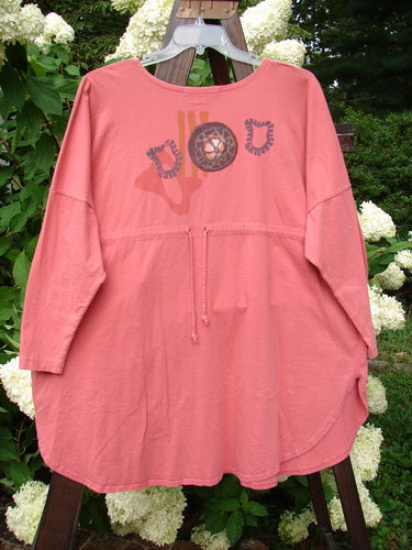 1996 Long Sleeved Pop Top Boulder City Oriole OSFA featuring a unique front pocket with textured ceramic button, oversized silhouette, gently scooped rolled neckline, and rear drawcord back.