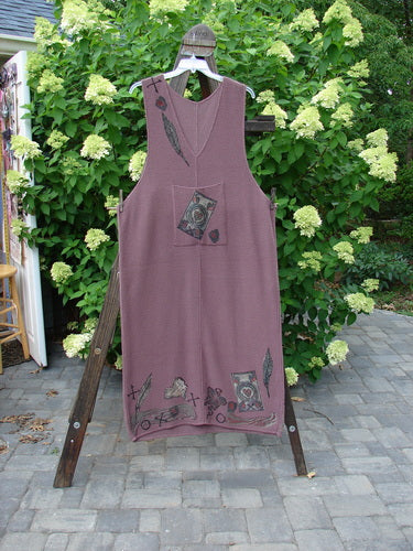 1993 Waffle Pocket Sweater Jumper Heart Feather Dusty Plum Size 2 hangs on a wooden rack, featuring an oversized front pocket with painted heart feather theme, deeper arm openings, and a plunging V neckline.