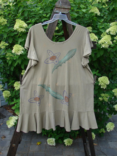 1996 Butterfly Dress Feather Flower Nest Size 2 displayed on a swing, featuring short ruffled sleeves, a ruffled hem flounce, deep rounded neckline, and slight A-line flair with floral design.