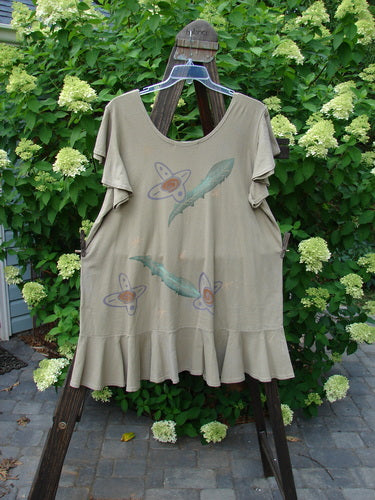 1996 Butterfly Dress Feather Flower Nest Size 2 hanging on a rack, featuring shorter ruffled sleeves, lower ruffled hem flounce, deep rounded neckline, and feather flower paint design.