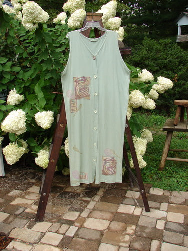 1995 Arbor Vest Kitchen Mixer Dinette Green OSFA displayed on a clothes rack, showcasing a deep V-shaped neckline, rounded hemline, front painted pocket, and original Blue Fish recycled paper buttons.
