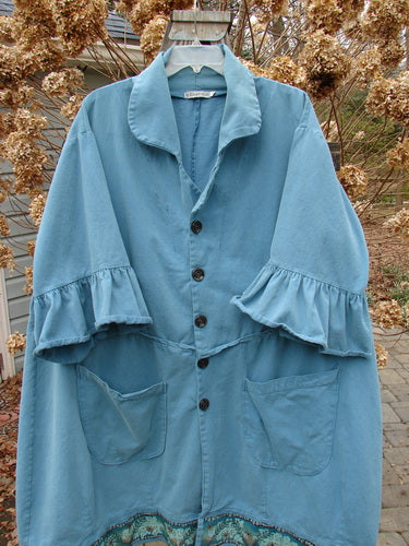 Barclay Decora Brushed Twill Flutter Coat in Peacock, size 2. A blue coat with a deep V neckline, dark buttons, flutter sleeves, and a swingy hemline. Features a vine garden theme and giant drop pockets.