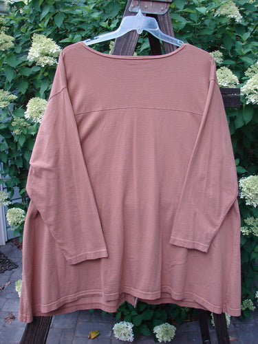Barclay Triangle Cardigan Unpainted Dusty Ochre Size 2, long-sleeved on a clothes rack, featuring a deep V-neckline, angled front pockets, and a widening lower hem.