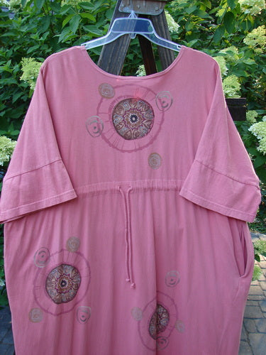 Barclay Naiad Dress Medallion Glow Size 2: A pink dress with a super tapered lower shape, generous bust measurement, and shorter sectional lower sleeves. Features a super rounded and vented hemline, two deep side pockets, and a dynamic Barclay medallion theme paint. Length is 54 inches.