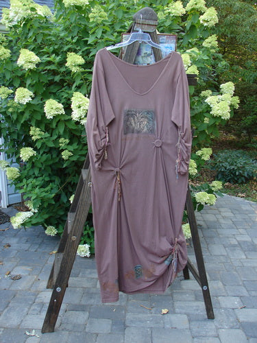 1994 Deep Neck Dress Embellished Forest Dusty Plum Size 2 displayed on a rack, showcasing intricate fish embellishments, mixed silk and cotton ribbons, and a tapering lower hem with forest-themed paint.