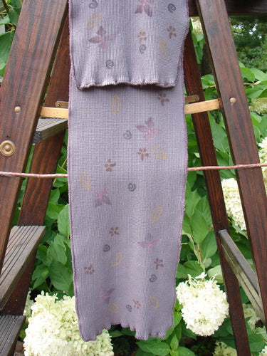 Barclay Thermal Double Layered Scarf with Tiny Floral Accents in Light Plum. Sweet curly edges and waffle texture. Cozy and stretchy. Measures 8" wide and 52" long.
