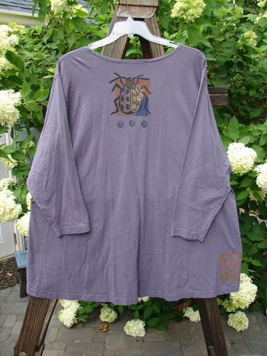 1996 Triangle Cardigan Garden Bug Purple Martin OSFA: A purple shirt with a bug on it, featuring a deep V neckline, angled front pockets, and a varying hemline. Made from mid-weight organic cotton.