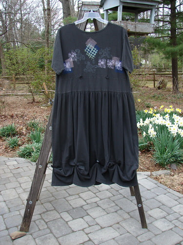 1996 Constellation Dress Garden Path Storm Size 2, featuring an adjustable hemline with loops and buttons, full gathered skirt, and scooped neckline, displayed on a rack with floral-themed design accents.