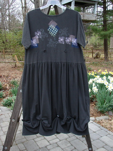 1996 Constellation Dress Garden Path Storm Size 2 displayed on a rack, featuring an adjustable hemline with loops and buttons, scooped neckline, and full skirt with garden path theme paint.