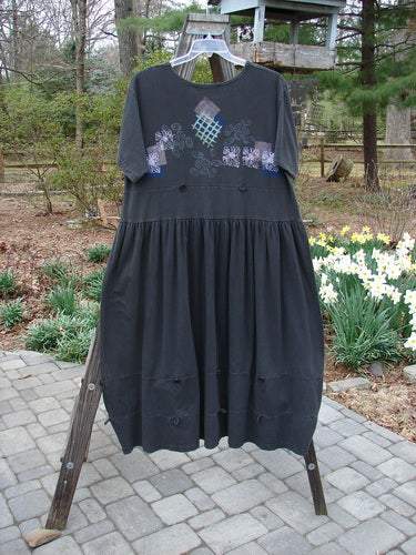 1996 Constellation Dress Garden Path Storm Size 2, displayed on a rack, features a creatively accented adjustable hemline with continuous loops and buttons, plus a deeper scooped neckline and garden path theme design.