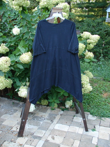 Barclay NWT Vector Tunic Dress Unpainted Black Size 2 displayed on a clothes rack, showcasing its unique hemline and V-shaped neckline.