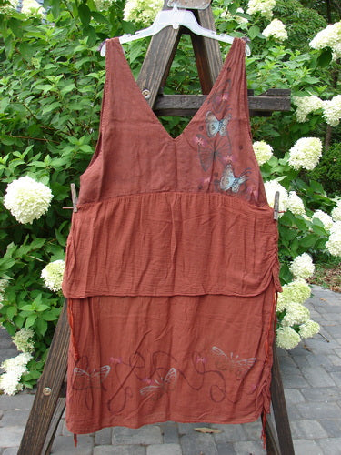 Barclay Gauze Linen Two Tier Ribbon Jumper Butterflies Cinnabar Size 1 features variegated silk ribbon shoulder ties, lace-up bodice, and butterfly-themed paint, displayed hanging outdoors on a clothesline.