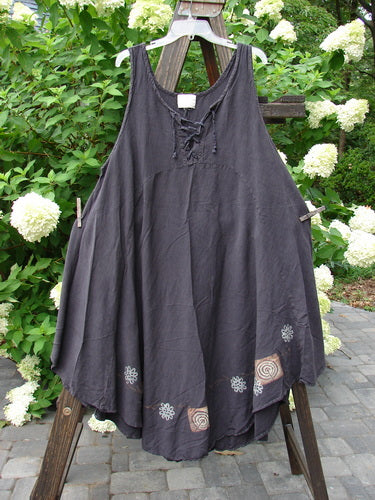 2000 Lace Up Jumper Pinwheel Raven Size 2: A dress on a clothes rack with a seriously varying hemline and a laced front.