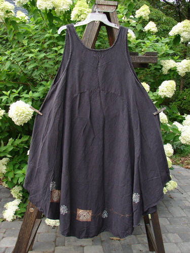 2000 Lace Up Jumper Pinwheel Raven Size 2: A black dress on a wooden easel, with a seriously varying hemline and a beautifully rounded and rolled neckline.