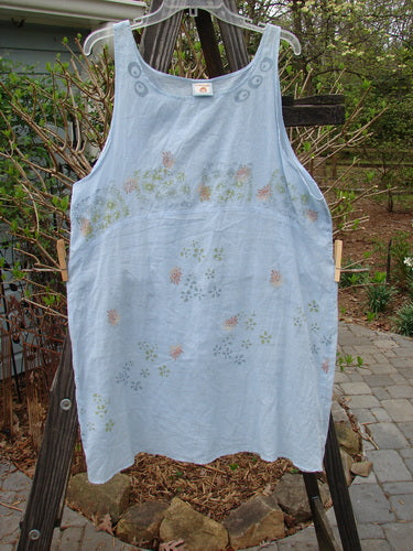 A Barclay Batiste Slip Dress with Continuous Tiny Floral Birdsong design, made from Feather Weight Cotton Batiste. Features include a rounded neckline, widening lower, deeper arm openings, and a downward curved empire waist seam front with a seamless back. Bust 46, Waist 46, Hips 48, Sweep 55, Length 36.