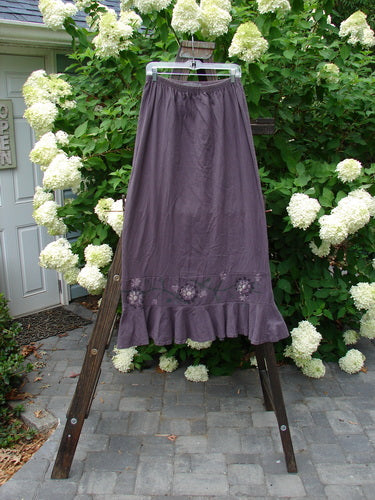 1996 Spring Laughter Skirt Vine Blossom Violet Field Size 2 on a wooden rack, showcasing its full elastic waistband, slimming drape, and detailed vine blossom design with an 8-inch lower band.