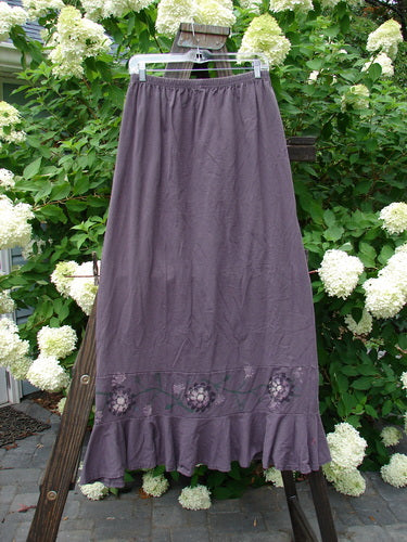 1996 Spring Laughter Skirt Vine Blossom Violet Field Size 2, displayed hanging on a clothesline, featuring a full elastic waistband and detailed vine blossom design on organic cotton.