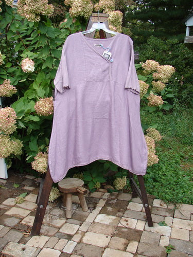 Barclay NWT Linen Lace Blooming Tunic Dress in Lavender, featuring a cross-over neckline, empire waist seam, scalloped three-quarter sleeves, lace hem, and an A-line shape.