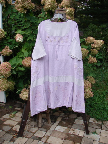 Barclay Linen Contrast Drop Pocket Dress Tiny Flower Heathered Lilac Size 2: A dress on a swinger with a purple flower design, shallow drop pockets, and a flutter flounce.
