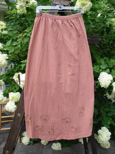 1998 Botanicals Corolla Skirt Digitalis Magnolia Size 1, displayed on a clothesline, features a full elastic waistband and an upward scooped front hemline with a botanical theme, showcasing its slender design.