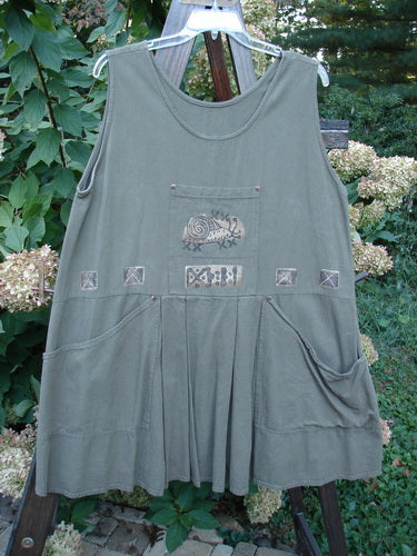 1995 Invention Smock The Garden Snail Bramble OSFA displayed on a clothesline, showcasing front pleats, bib pocket, and snail-themed paint, exemplifying Bluefishfinder.com's unique vintage clothing style.