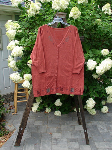 1993 Sticks and Stones Jacket, Windy Day Red Oro OSFA: A red shirt on a clothes rack with a deep V-shaped neckline, front snaps, and vented sides. Features 4 painted pockets and a Blue Fish signature patch. Bust 54, Waist 54, Hips 54, Length 34.